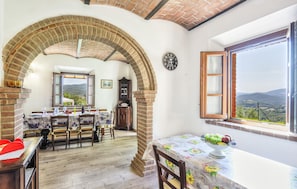 A dining area with a brick archway, wooden furniture, a clock, and a view of the countryside. - 3 bedroom gorgeous home in Montecatini Val Di Cec (Montecatini Val Di Cec)