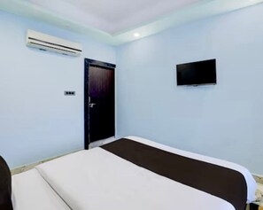 A room with a bed, an air conditioning unit, a door, and a television. - Hotel 5G (Bhopal)