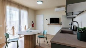 Une cuisine moderne équipée d’un four encastré, d’un évier et d’un téléviseur.