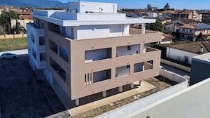 Un immeuble à plusieurs étages, doté de balcons, d’un toit plat et offrant une vue dégagée sur le quartier environnant.