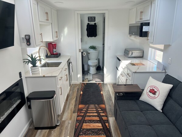 A compact kitchenette with a coffee maker, a microwave, and a sink.