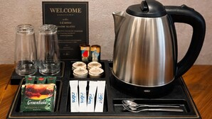 A coffee station with a stainless steel kettle, sugar packets, a spoon, and a welcome sign. - Urban nest old Tbilisi (Tbilisi)