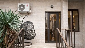 A staircase leading to a door with an air conditioning unit and a wall-mounted light fixture. - Urban nest old Tbilisi (Tbilisi)
