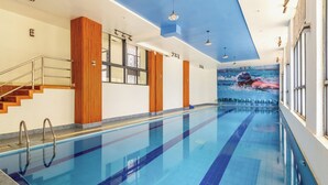 A swimming pool with a clear blue water, wooden paneling on the walls, and a staircase on the left. - 3-bedroom apartment in wonderful Nairobi with indoor pool and garden (Nairobi)