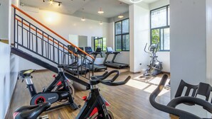 A gym with exercise equipment, a staircase, and large windows. - 3-bedroom apartment in wonderful Nairobi with indoor pool and garden (Nairobi)