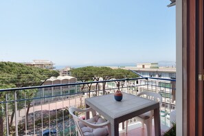 A balcony with a table and chairs, overlooking a street and buildings. - Apartment 'Le Stelle Di Zia Pina' with Sea View, Wi-Fi and Air Conditioning (Torre del Greco)