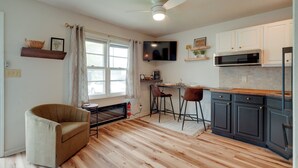 A kitchen with wooden flooring, a ceiling fan, a TV, and a microwave. - 5 Mi to Elephant Rocks State Park Condo (Ironton)