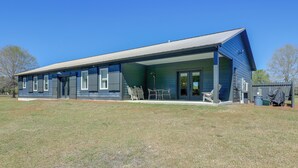 A modern two-story house with a covered porch, large windows, and a well-maintained lawn. - Patio w/ Pond & Forest Views! Havelock Retreat (Havelock)
