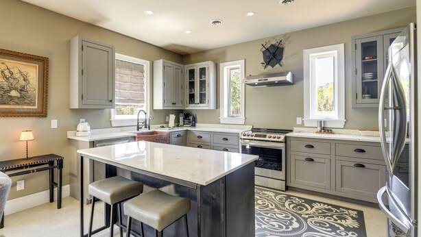 A modern kitchen with a central island, bar stools, a stove, and a refrigerator. - Patio w/ Pond & Forest Views! Havelock Retreat (Havelock)