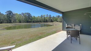 A patio with a view of a pond and trees, a table, and chairs. - Patio w/ Pond & Forest Views! Havelock Retreat (Havelock)