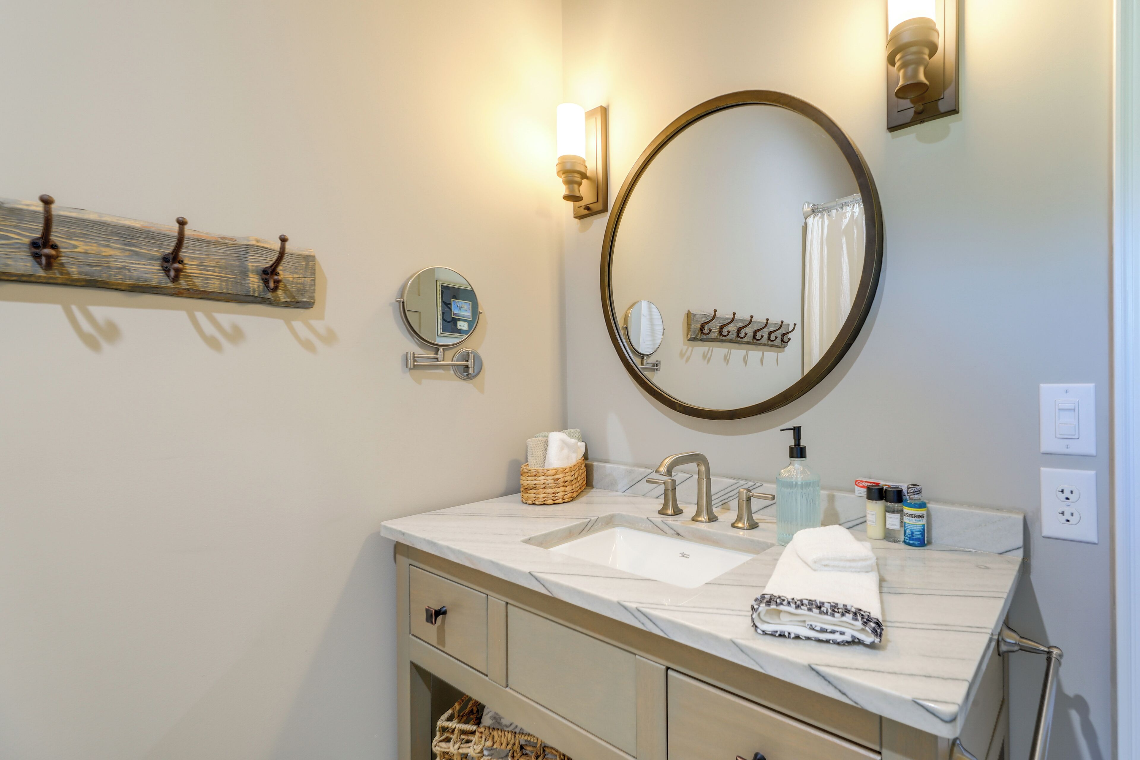 A bathroom with a sink, mirror, towel, and toiletries.