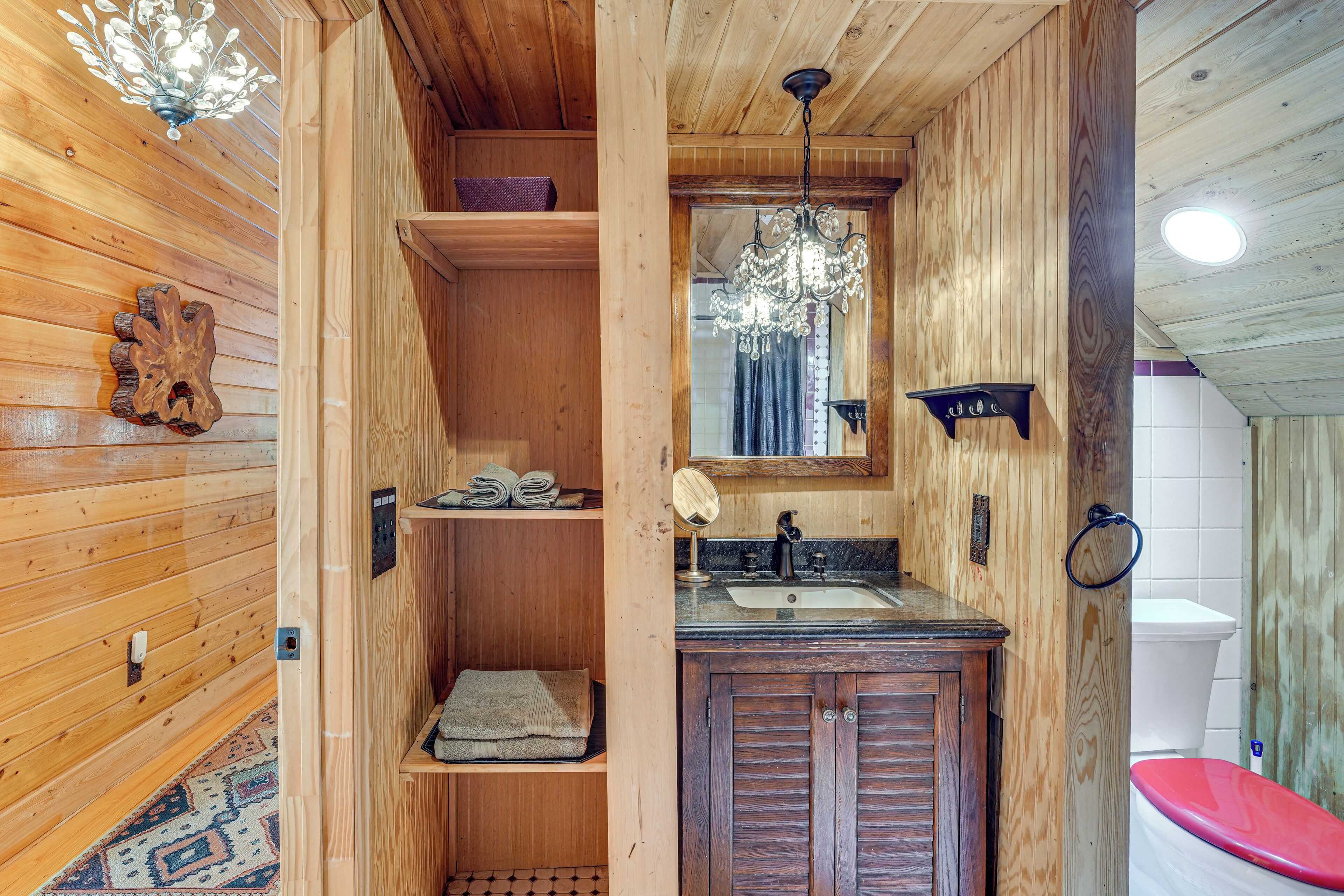 Un interior de madera con un lavabo, espejo y retrete.