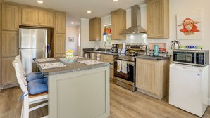A kitchen with wooden cabinets, stainless steel appliances, and a central island.