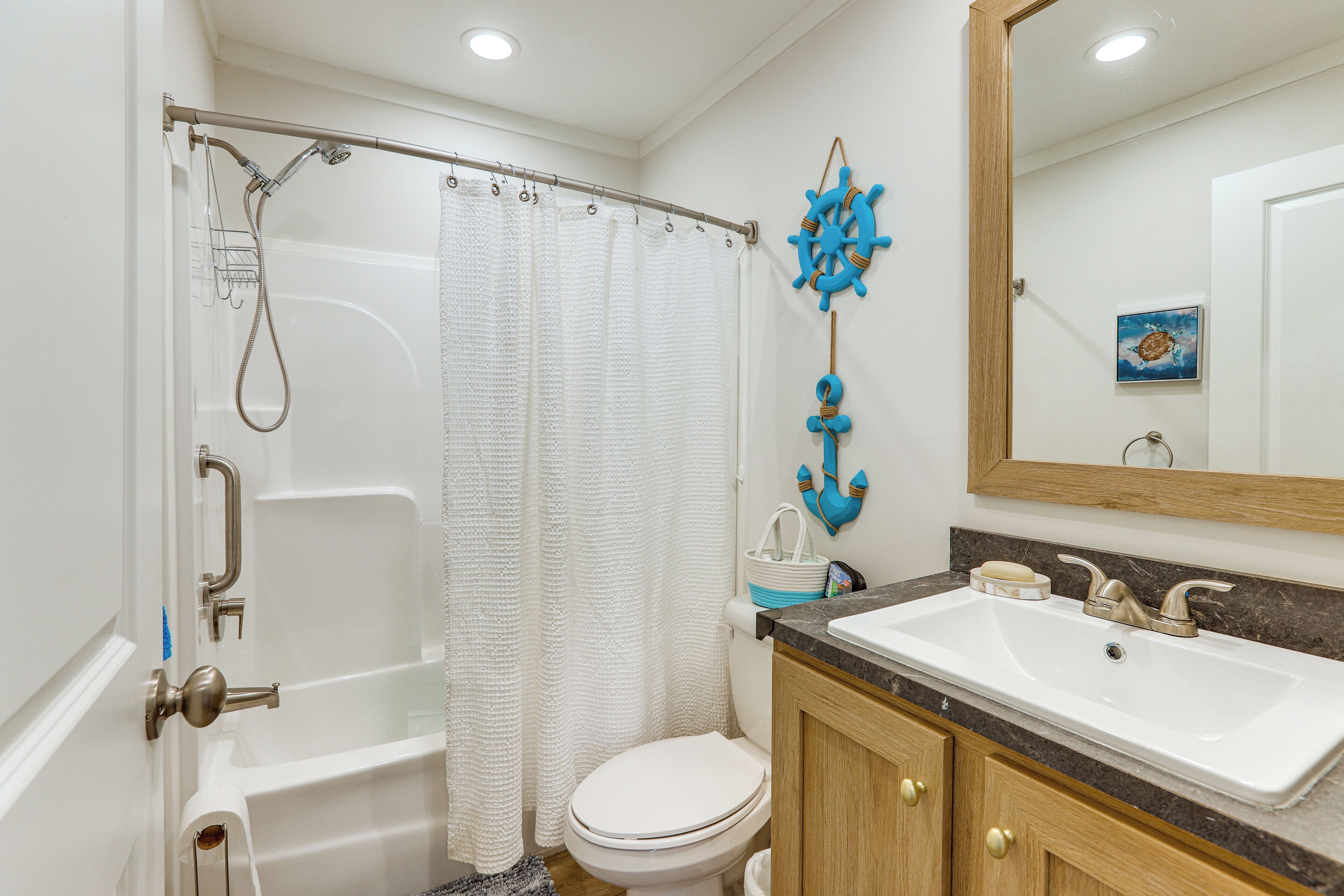 A bathroom with a bathtub, toilet, sink, and a mirror.