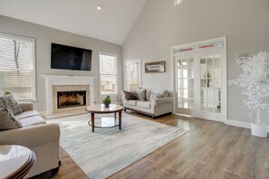 A living room with a fireplace, a sofa, a coffee table, and a television. - Private Yard & Pool Access! Family Home in Acworth (Acworth)