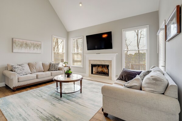 A living room with a fireplace, two sofas, a coffee table, and a TV. - Private Yard & Pool Access! Family Home in Acworth (Acworth)