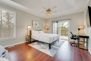 A bedroom with a bed, a desk, a chair, a ceiling fan, and a large window. - Private Yard & Pool Access! Family Home in Acworth (Acworth)