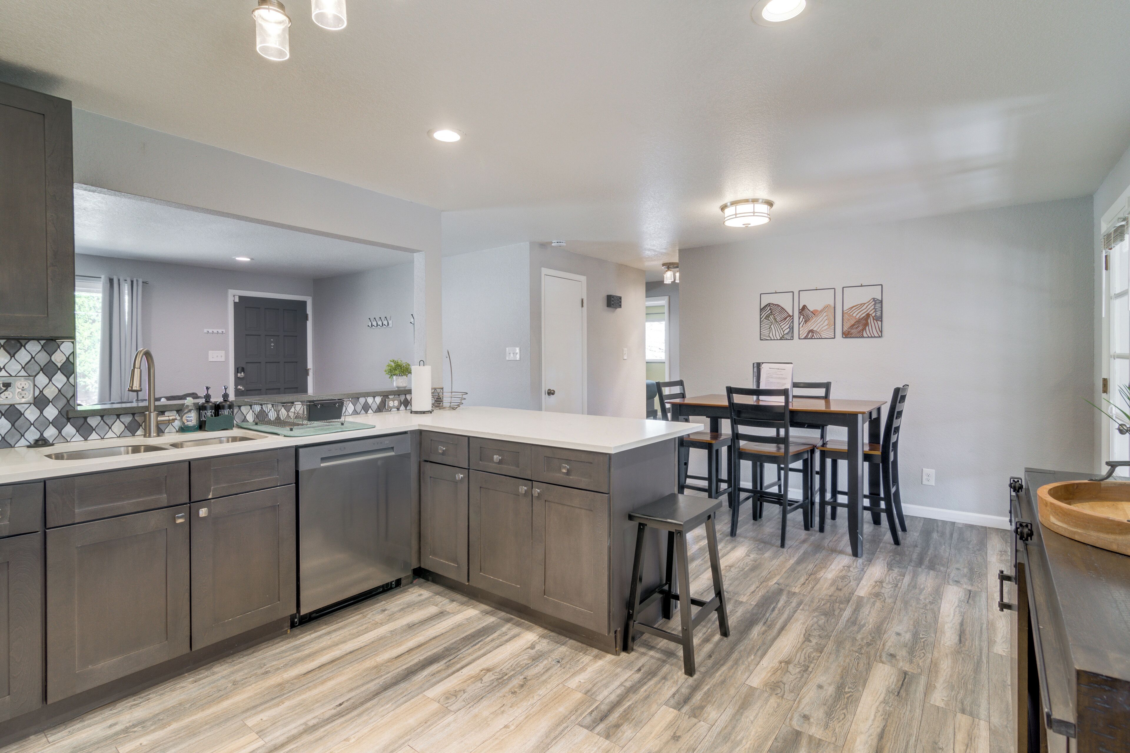 Una cocina moderna con una isla central, electrodomésticos integrados y un comedor con mesa y sillas.