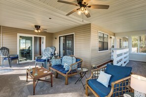 A covered outdoor seating area with wicker furniture, ceiling fans, and a view of the outdoors. - Gwynn's Island Gem Private Beach & Bay Views (Gwynn)