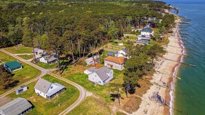 An aerial view of a coastal residential area with houses, a beach, and a pier. - Gwynn's Island Gem Private Beach & Bay Views (Gwynn)