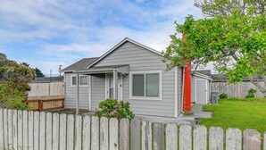 A single-story house with a front porch, a wooden fence, and a small garden. - Near Ocean & Redwood National Park! Home w/ Yard (Crescent City)
