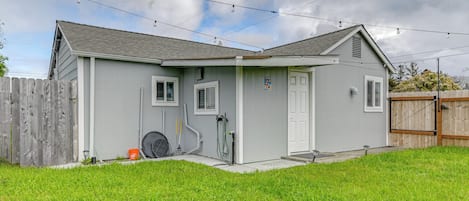 A single-story house with a grey exterior, a white door, and a small porch area.