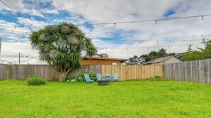 A backyard with a wooden fence, a tree, and a table with chairs. - Near Ocean & Redwood National Park! Home w/ Yard (Crescent City)