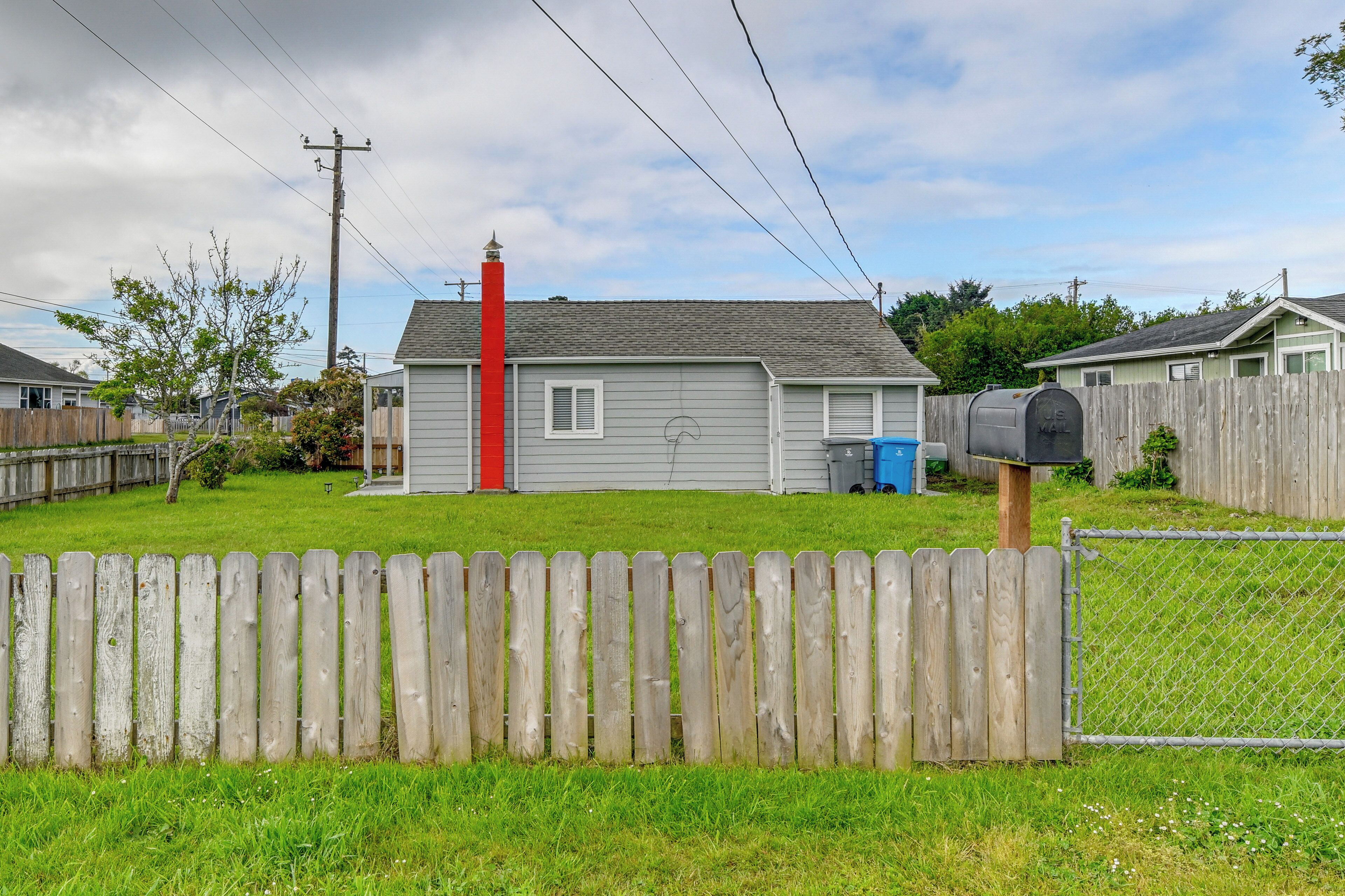 A residential property with a fenced yard, a mailbox, and a chimney.