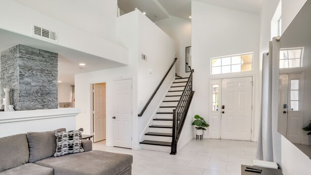 A spacious living area with a staircase, a sectional sofa, and a stone accent wall. - 6 Mi to Strip & Chinatown! Poolside Desert Escape (Las Vegas)