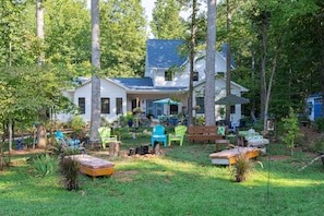 Een huis met een veranda, buitenzitplaatsen en een vuurkorf.