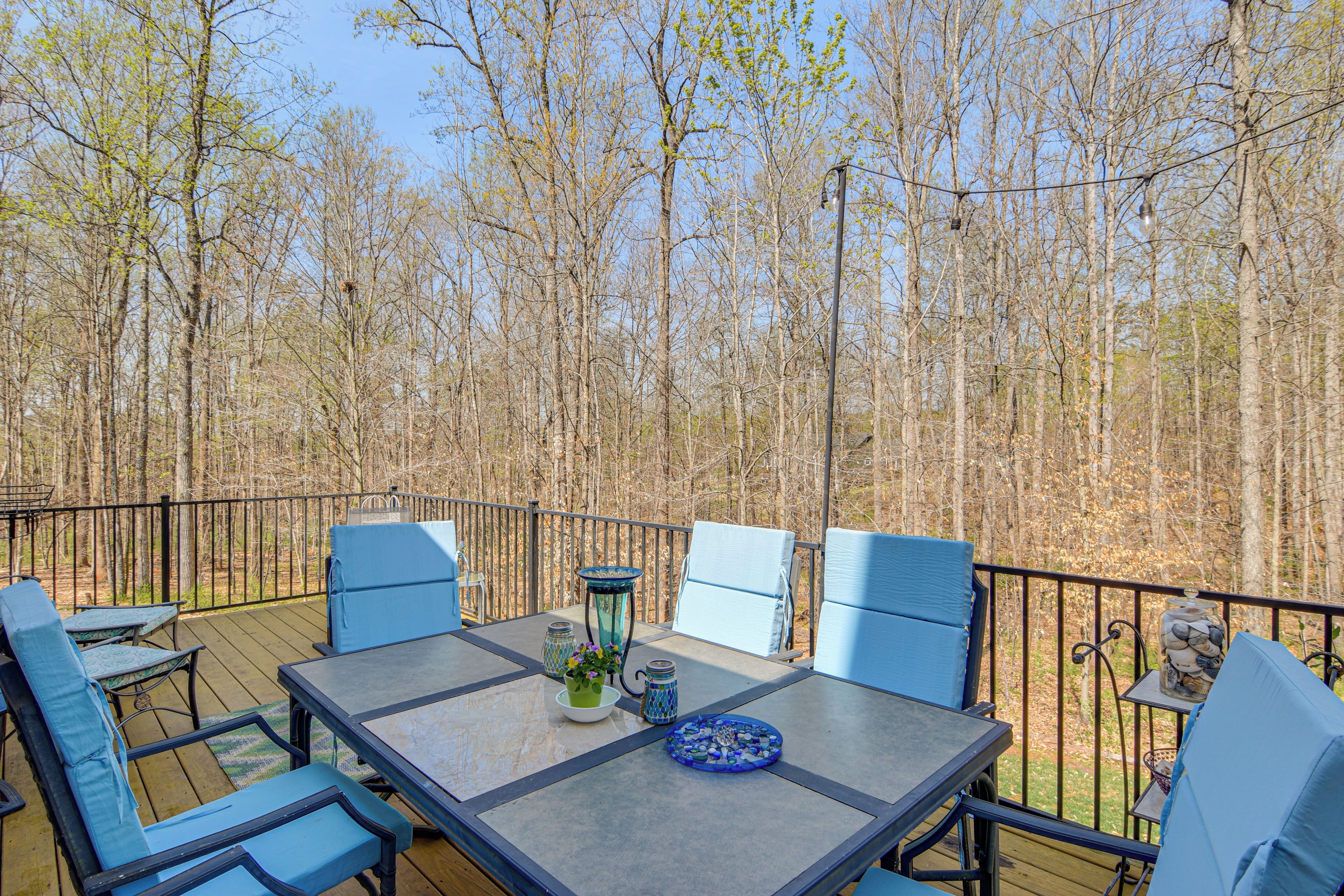 Une terrasse extérieure avec une table et des chaises, entourée d’arbres.