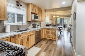A kitchen with wooden cabinets, a stainless steel dishwasher, and a granite countertop.