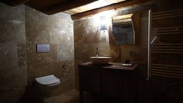 A bathroom with a toilet, a sink, and a mirror.