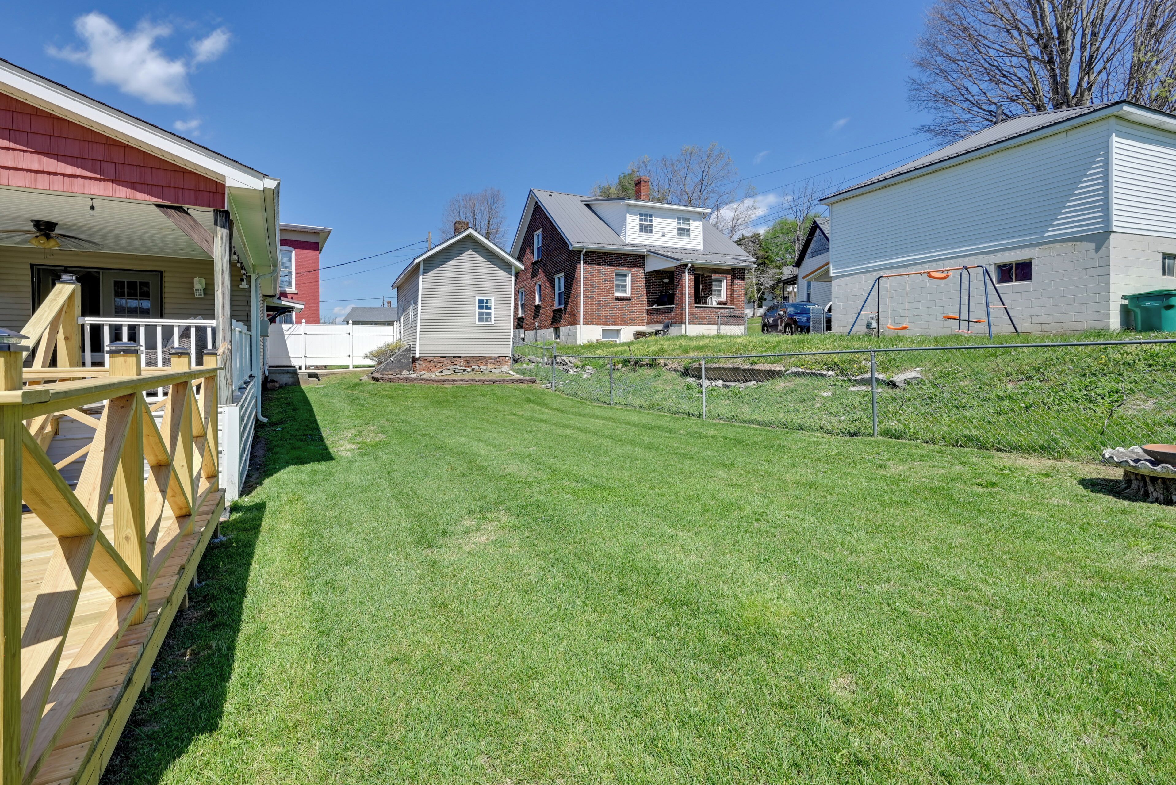 A residential area with houses, a fenced yard, and a clear sky.
