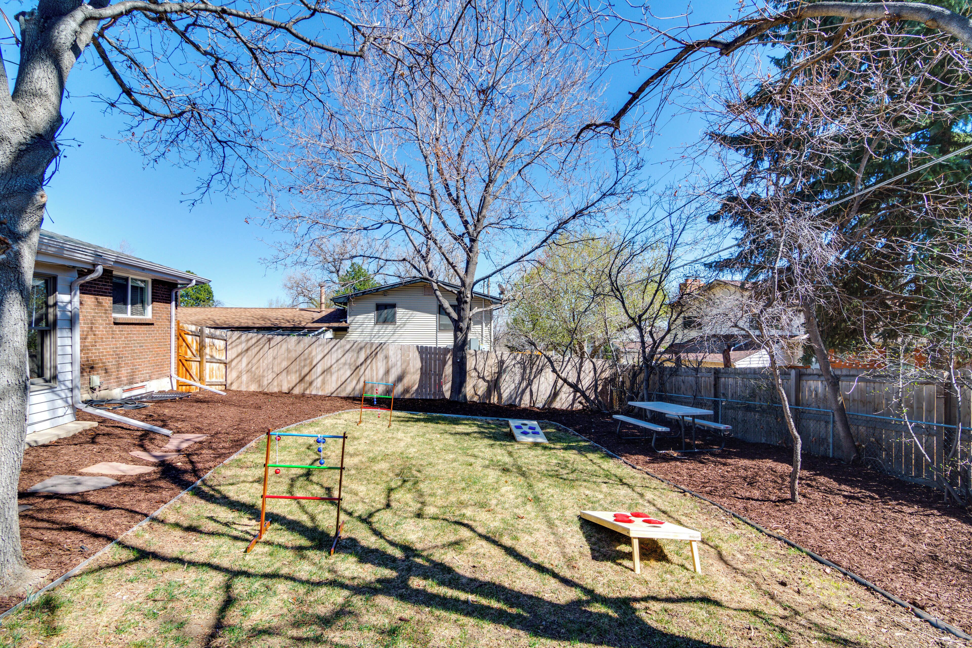 A backyard with a playset, a picnic table, and a shed.