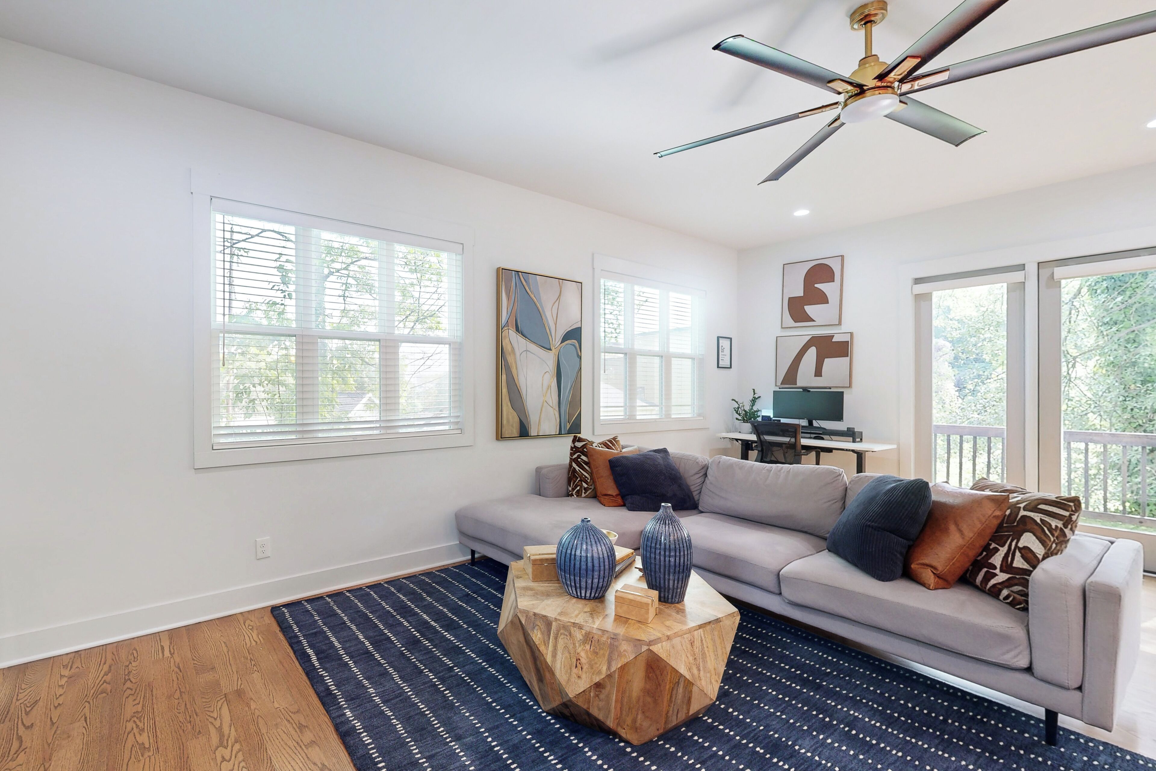 A modern living room with a sofa, coffee table, and artwork on the walls.