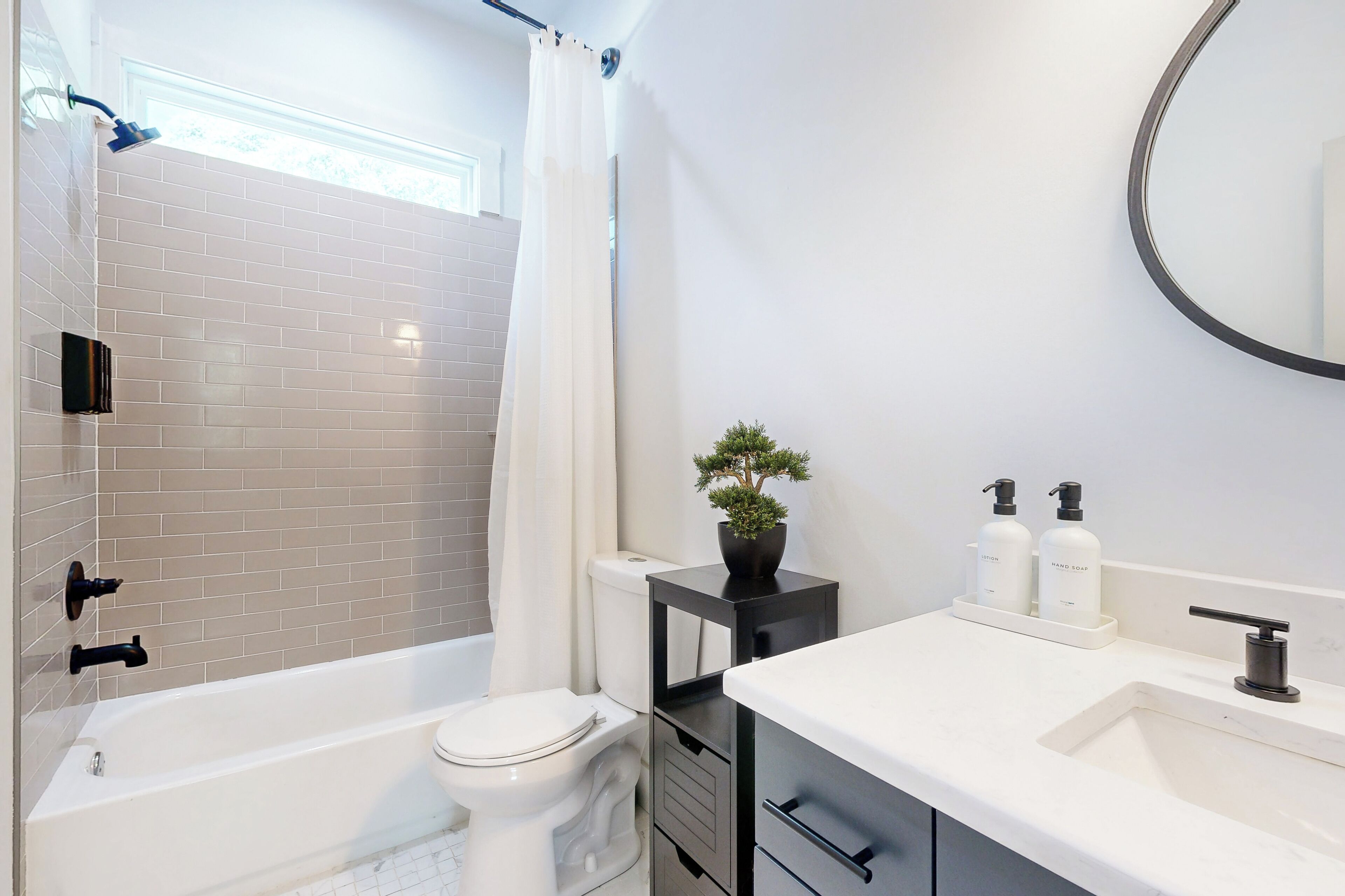Ein modernes Badezimmer mit Badewanne, Toilette und Waschbecken.