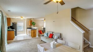 A spacious living area with a dining table, a sofa, and a kitchen in the background.