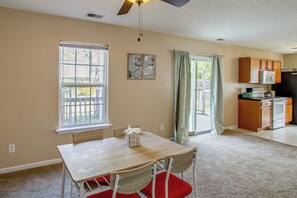 A dining area with a table and chairs, a kitchen with cabinets and appliances, and a window with a view. - Great for Military Families! Quiet Columbia Home (Blythewood)