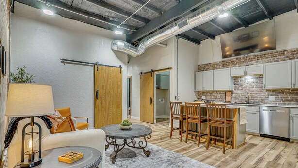 Una sala moderna con sofá, mesa de centro y comedor.