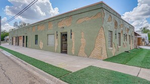 A building with a green facade, brickwork, and a flat roof.