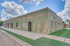 Un edificio con fachada verde, ladrillo y techo plano.