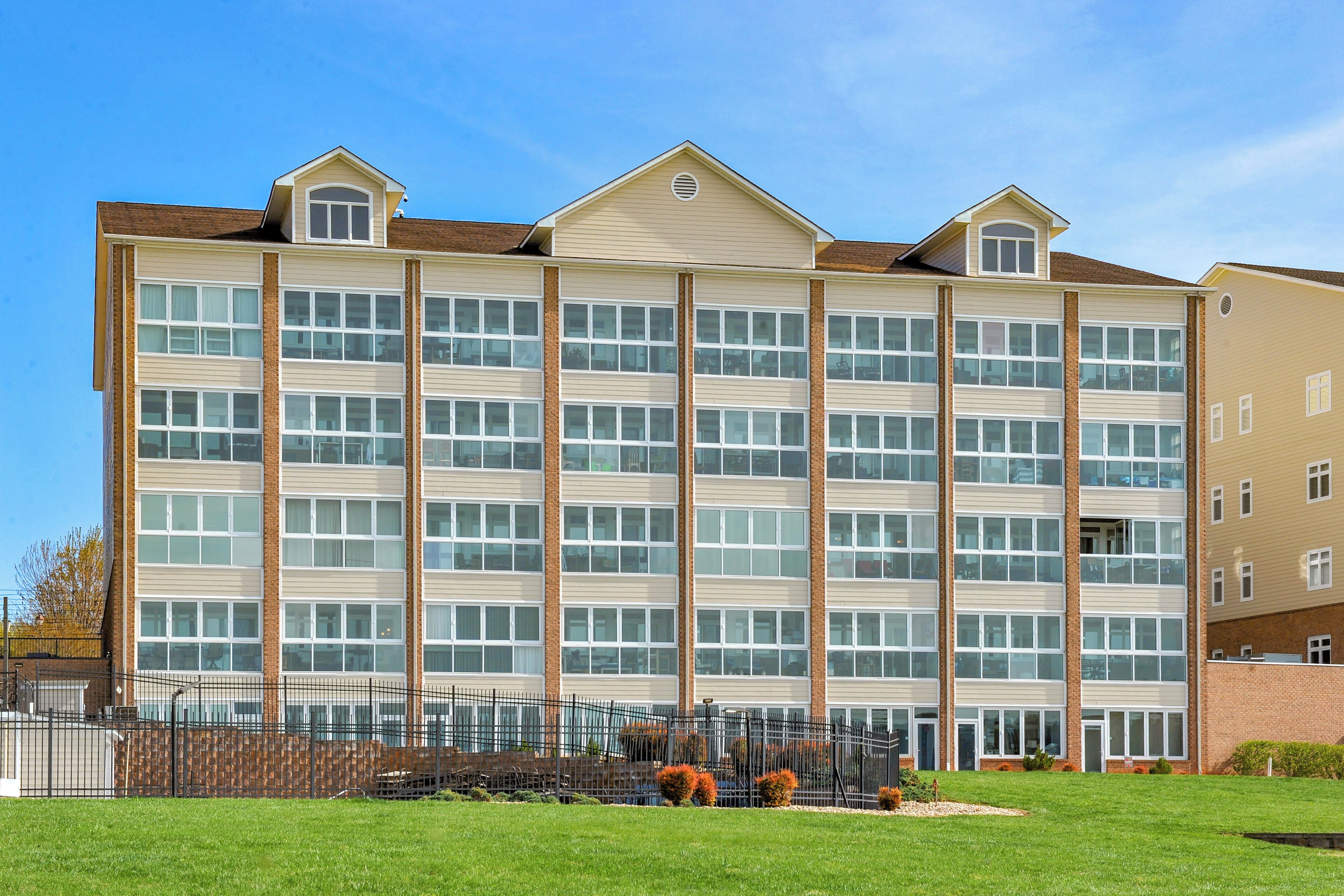 A multi-story hotel with a brick facade, large windows, and a flat roof.