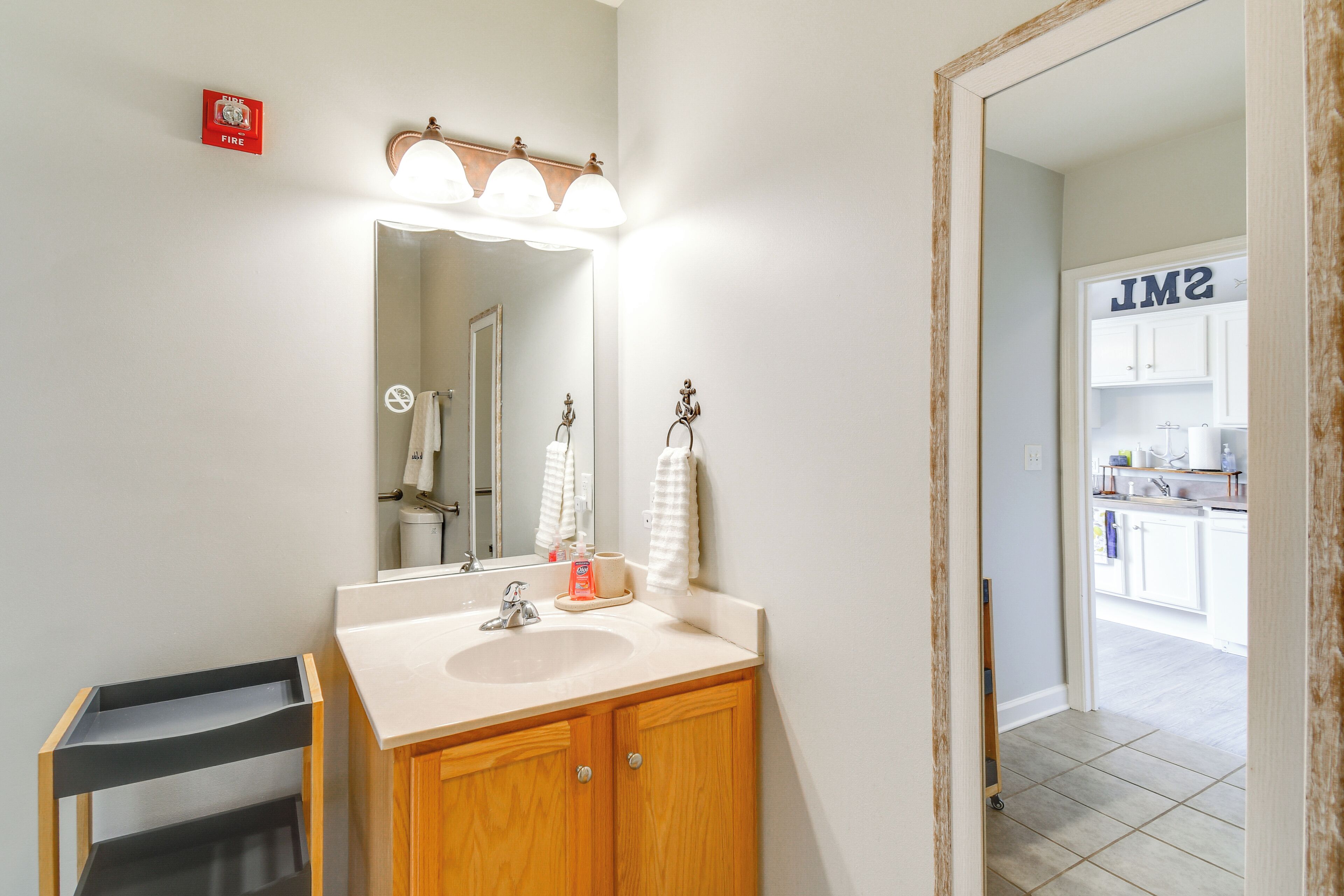 A bathroom with a sink, mirror, and towel rack.