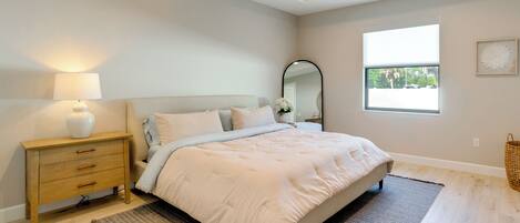 A bedroom with a bed, bedside table, lamp, and a ceiling fan.