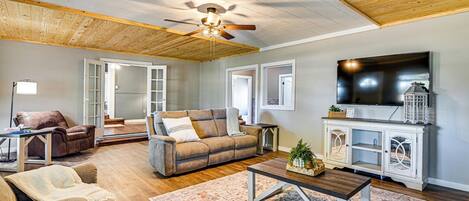A living room with a ceiling fan, a television, a cabinet, and a sofa.