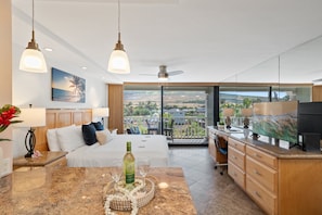 A hotel room with a bed, a desk, a balcony with a view, and a large window. - Mountain View Studio at Beachfront Resort in West Maui - Lahaina Shores 320 (Lahaina)