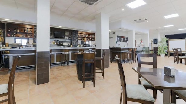 A spacious restaurant with a bar area, multiple seating options, and a modern interior design.
