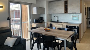 Una cocina moderna con comedor, sofá y vistas al exterior.