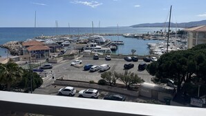 Una marina con barcos, un edificio con un letrero y un estacionamiento con automóviles.